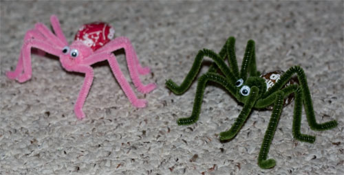 Pink and green lollipops made into spiders with chenille-stem legs and googly eyes